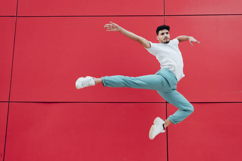 Male gymnast dancing in front of red wall - MIMFF00723