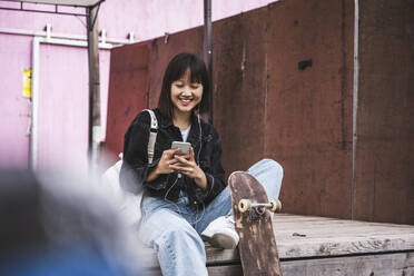 Teenager-Mädchen benutzt ihr Smartphone auf der Promenade - UUF24729