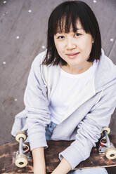 Female teenager with skateboard at park - UUF24741