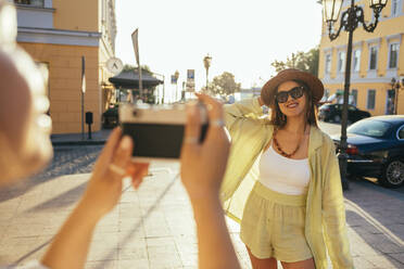 Junge Frau fotografiert Freund durch Kamera in der Stadt - OYF00532