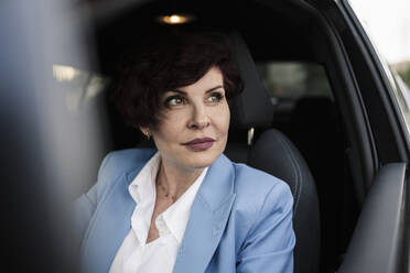Beautiful mature businesswoman with short hair sitting in car - JCCMF04053