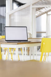 Blank screen laptop kept on desk in office - PESF03242