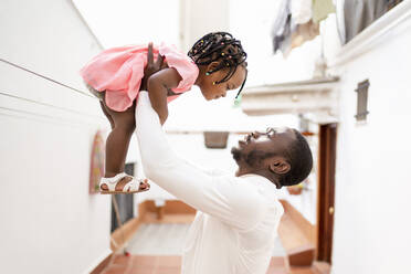 Young man lifting daughter - OCMF02243