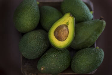 Avocados in basket on table - SIPF02453