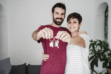 Mid adult couple holding house keys at home - EBBF04687