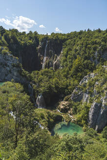 Blick auf einen Wasserfall und einen kleinen See im Nationalpark Plitvicer Seen - JAQF00839