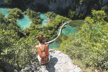 Wanderin bewundert die Landschaft des Nationalparks Plitvicer Seen vom Rand einer Klippe aus - JAQF00842