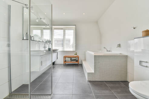 Zeitgenössische Badezimmereinrichtung mit Dusche gegen Badewanne und Fenster im Haus mit Fliesenboden - ADSF30748