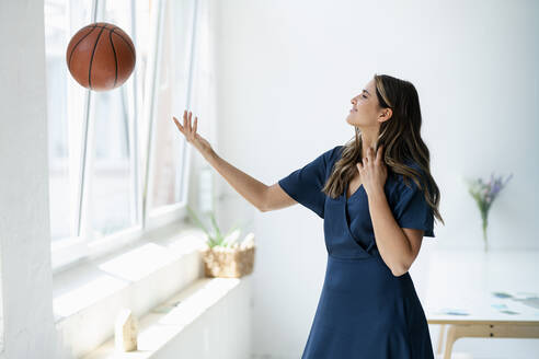 Junge Geschäftsfrau spielt mit Basketball im Büro - KNSF09184