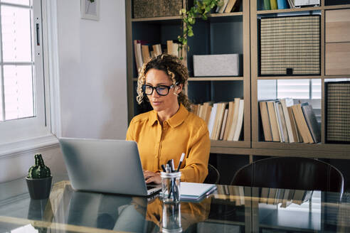 Schöne Frau arbeitet am Laptop am Schreibtisch - SIPF02485