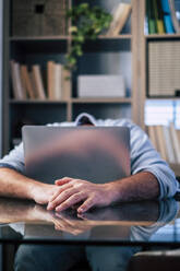 Tired businessman napping at desk in home office - SIPF02490