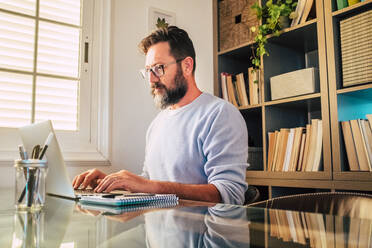 Mature businessman working on laptop at home - SIPF02504