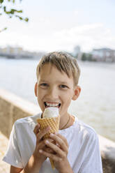 Happy boy with blond hair enjoying ice cream - EYAF01780