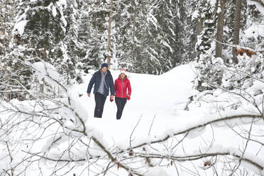 Mann und Frau gehen im Winter auf Schnee - HHF05697