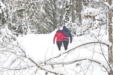 Mann und Frau mit Arm um einander zu Fuß auf Schnee im Winter - HHF05700