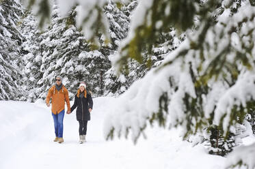 Mann und Frau genießen ihre Freizeit bei einem Schneespaziergang im Winter - HHF05723