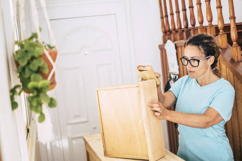 Weiblicher Handwerker beim Schleifen von Holz zu Hause - SIPF02514