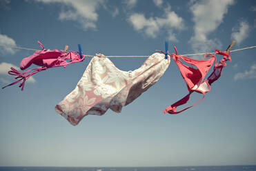 Bikini's on clothesline during sunny day - AJOF01657