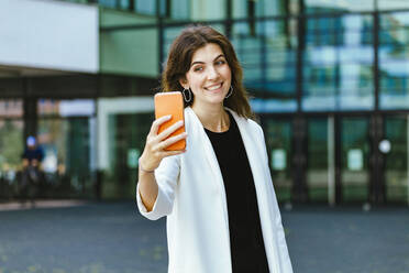 Smiling female freelancer taking selfie through mobile phone - IHF00535