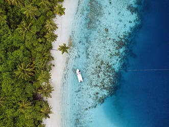 Malediven, Kolhumadulu-Atoll, Luftaufnahme eines Motorboots, das im Küstenwasser der Insel Kanimeedhoo treibt - KNTF06400