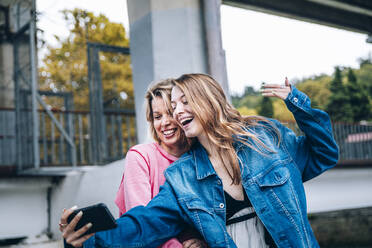 Teenager-Mädchen nimmt Selfie mit Frau durch Smartphone - OMIF00111
