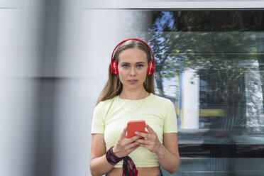 Frau mit drahtlosen Kopfhörern und Smartphone - PNAF02372