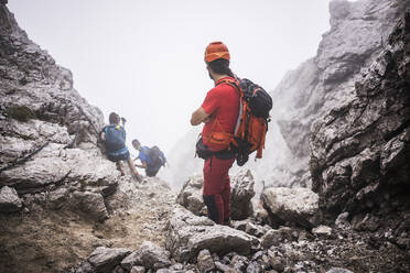 Männliche Wanderer mit Rucksack beim Wandern auf einem Berg - MCVF00901