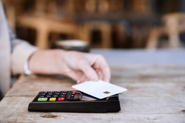 Businesswoman paying through credit card at cafe - EBBF04732