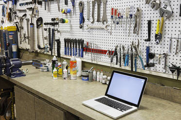 Cycle repair shop interior, tool boards and tools at a service counter. - MINF16373