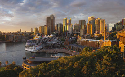 Cruise ship docked in Sydney Harbour with skyscrapers behind. - MINF16394