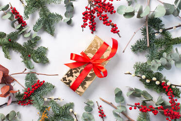 Weihnachtsdekoration auf weißem Hintergrund und ein eingepacktes Geschenk - MINF16410