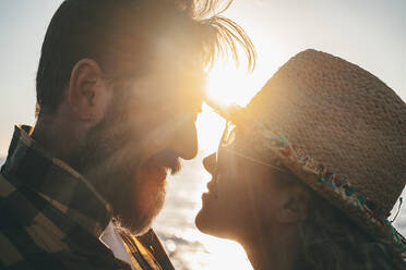 Bearded man romancing with girlfriend during sunset - SIPF02552