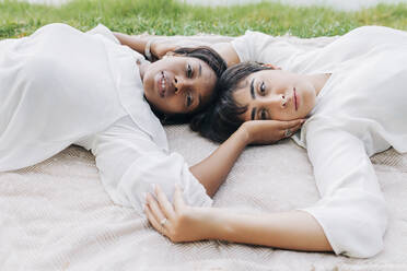 Lesbian women lying on blanket - JRVF01927