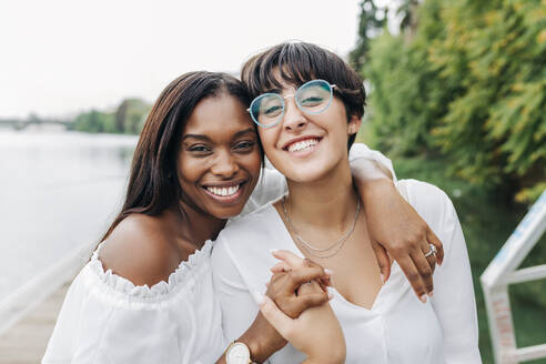 Cheerful female friends at lakeshore - JRVF01961