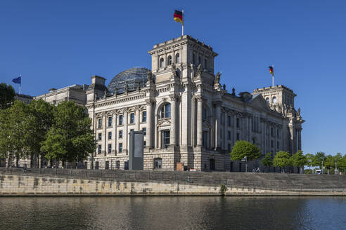 Germany, Berlin, Reichstag with bank of Spree in foreground - ABOF00704