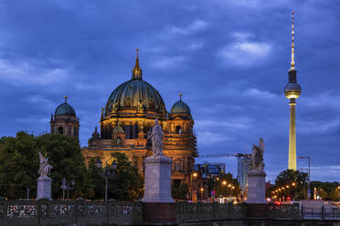 Germany, Berlin, Sculptures of Schlossbrucke at night with Berlin Cathedral and Berlin Television Tower in background - ABOF00763