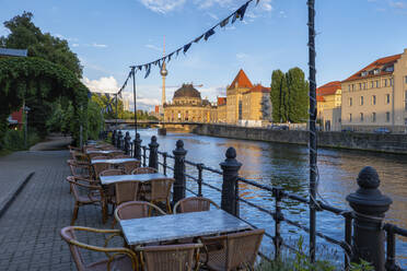 Deutschland, Berlin, Leere Restauranttische entlang des Spreekanals in der Abenddämmerung - ABOF00767