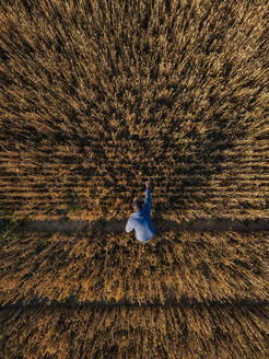 Mann prüft Roggenernte auf einem landwirtschaftlichen Feld bei Sonnenuntergang - KNTF06408