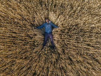 Carefree man lying on rye field - KNTF06410