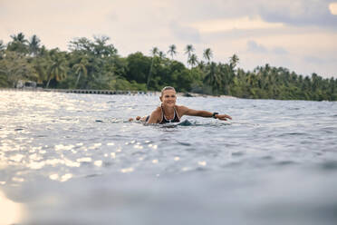 Smiling woman swimming in water - KNTF06482