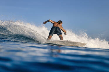 Mann ohne Hemd beim Surfen auf dem Wasser - KNTF06488