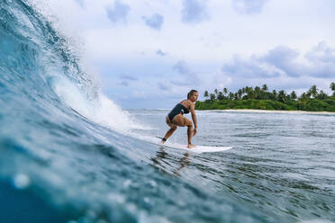 Mid adult woman balancing on surfboard - KNTF06494