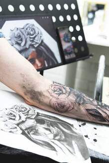 Mann mit Tätowierung auf dem Arm im Studio - JAQF00845