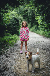 Mädchen mit Hund im Wald stehend - OMIF00123