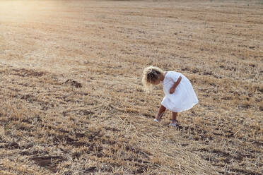 Little blonde girl alone in a field on a sunny day - ADSF30998