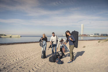 Männliche und weibliche Freunde mit Rucksäcken am Strand - MASF25770