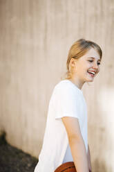 Happy girl with ball looking away at sports court - MASF26031