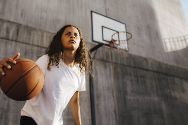 Pre-adolescent girl dribbling ball at sports court - MASF26040