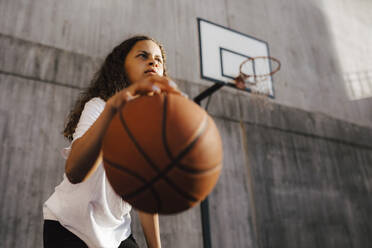 Determinant girl dribbling ball at sports court - MASF26041