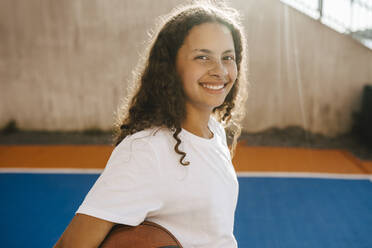 Porträt eines glücklichen vorpubertären Mädchens auf dem Sportplatz - MASF26051